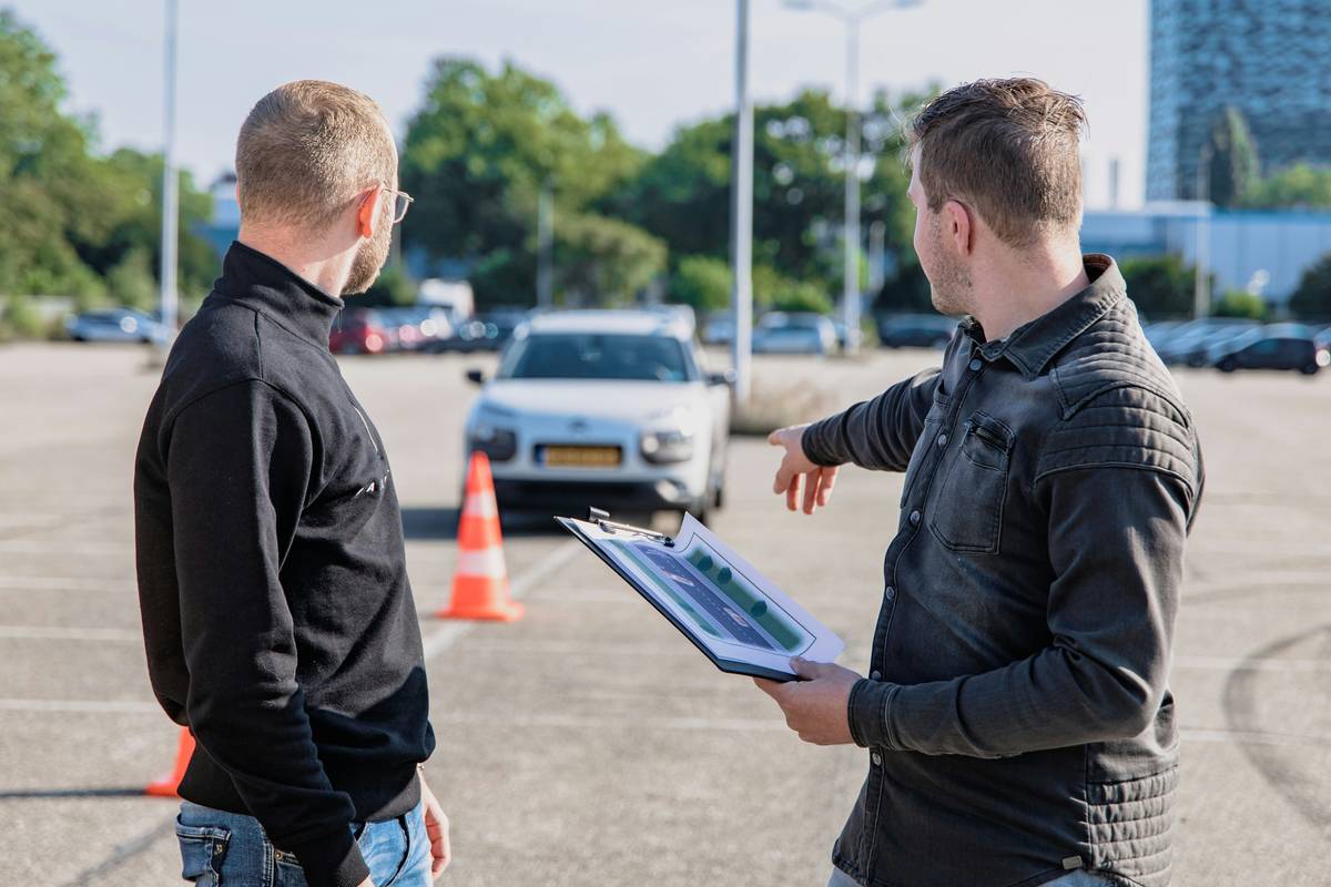 Mechanic reviewing a printed car maintenance schedule with owner — how to check car maintenance schedule