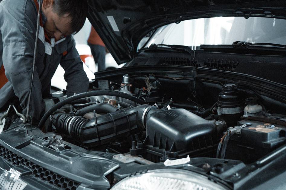 Close-up of hands performing car maintenance with tools on a clean garage workbench